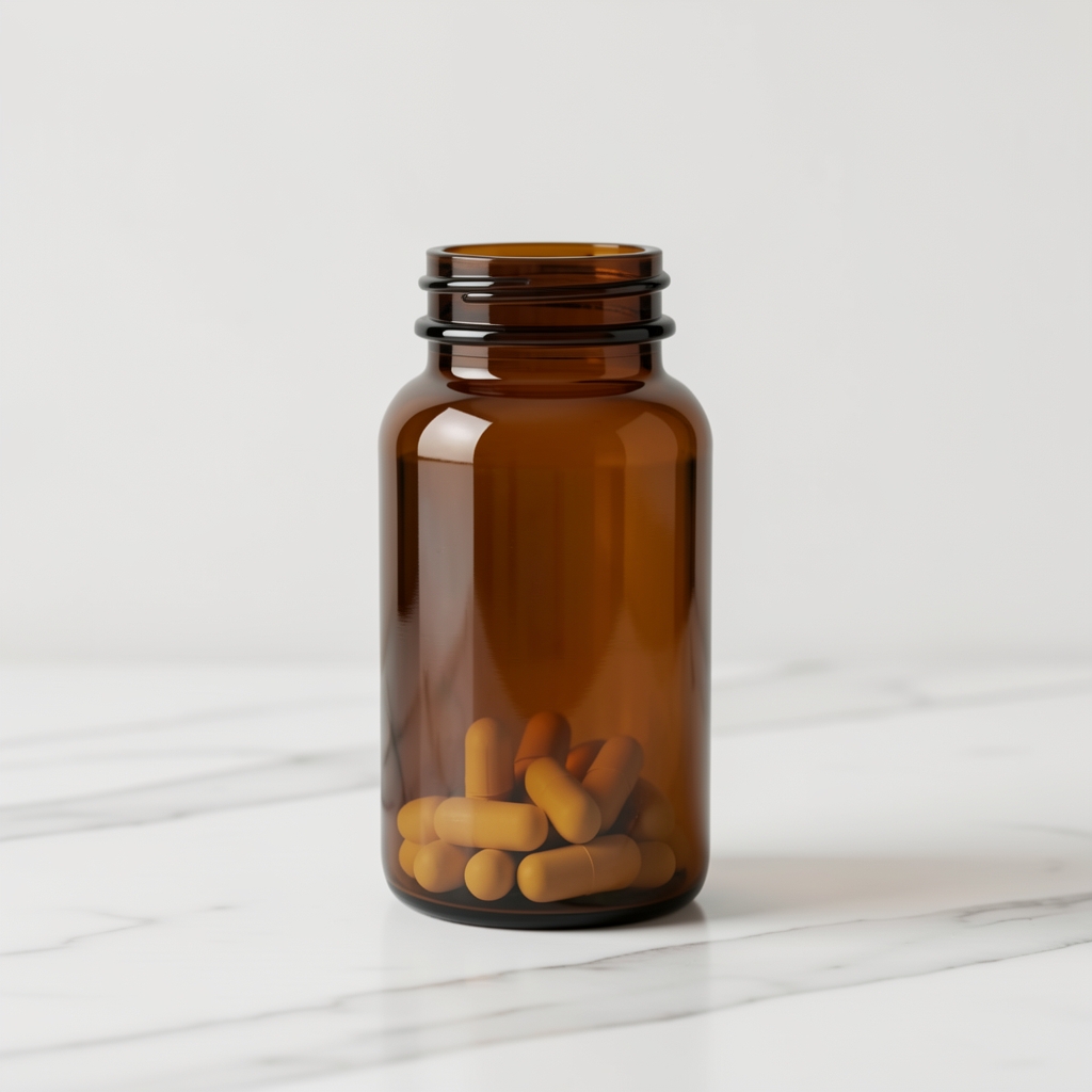 Dark amber vitamin supplement bottle standing upright on white marble surface with clean minimal background